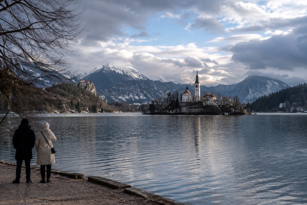 The island church on Lake Bled under low winter light with snow on the mountains behind