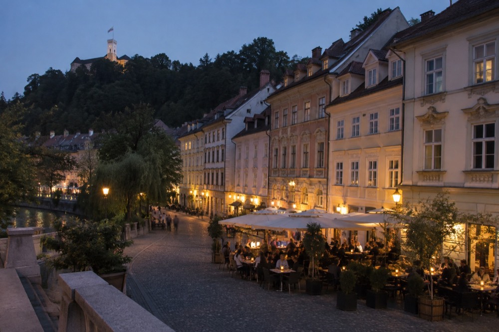 Evening diners at tables on a cobbled square in Ljubljana's old town