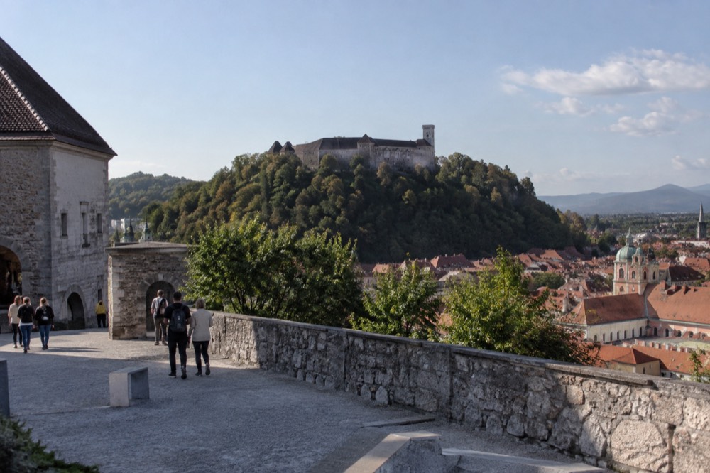 Ljubljana Castle walls and tower above the red rooftops of the old city centre