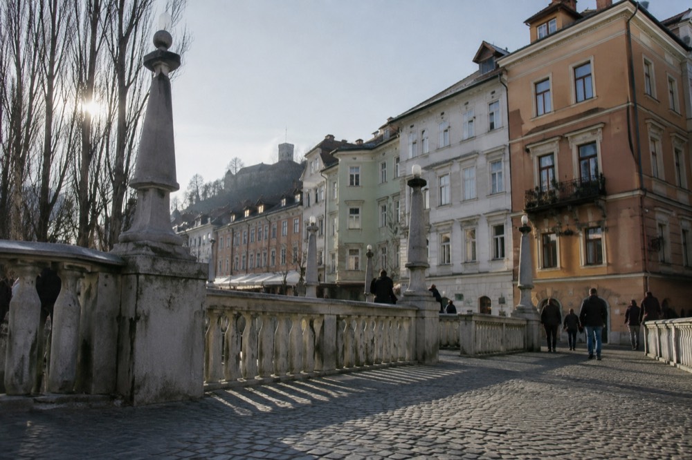 A street of colourful baroque buildings along the Ljubljanica river in the pedestrianised centre of Ljubljana