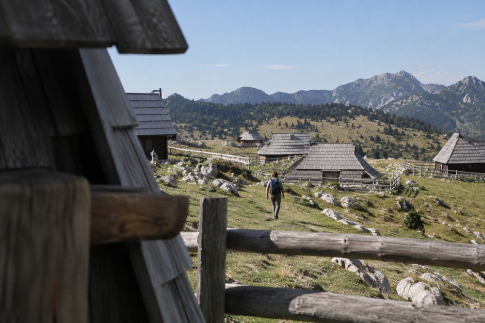 Wooden herdsmen's huts on the Velika Planina alpine plateau under a clear sky