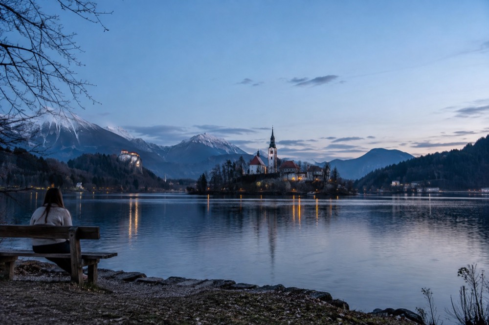 Lake Bled with the island church and forested shore under morning light