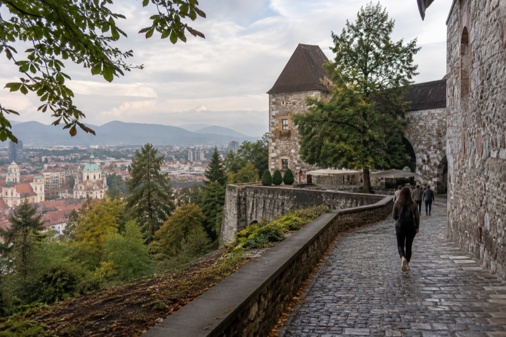 Ljubljana castle hill rising above the rooftops of the old town in soft morning light
