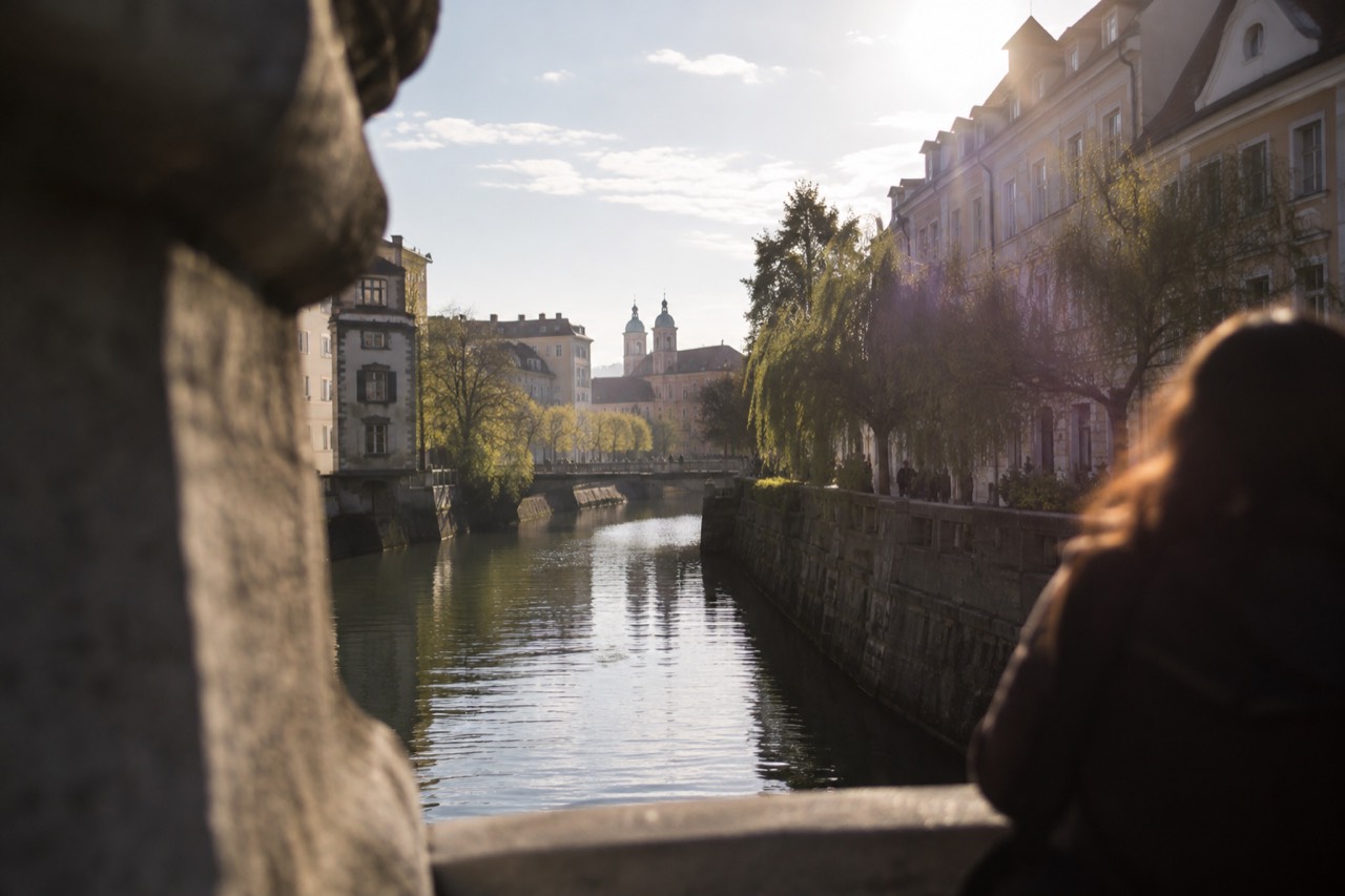 The Ljubljanica river and the old city centre of Ljubljana seen from a bridge on a bright morning