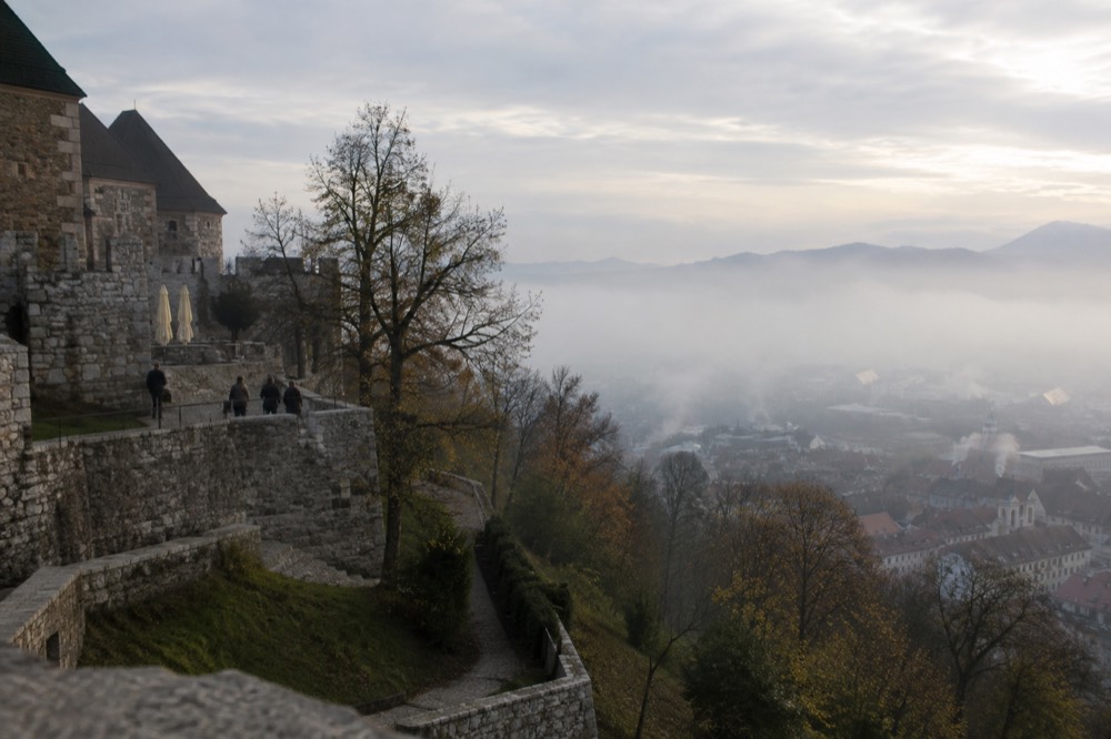Morning fog over the Ljubljanica river with the castle hill rising above the mist