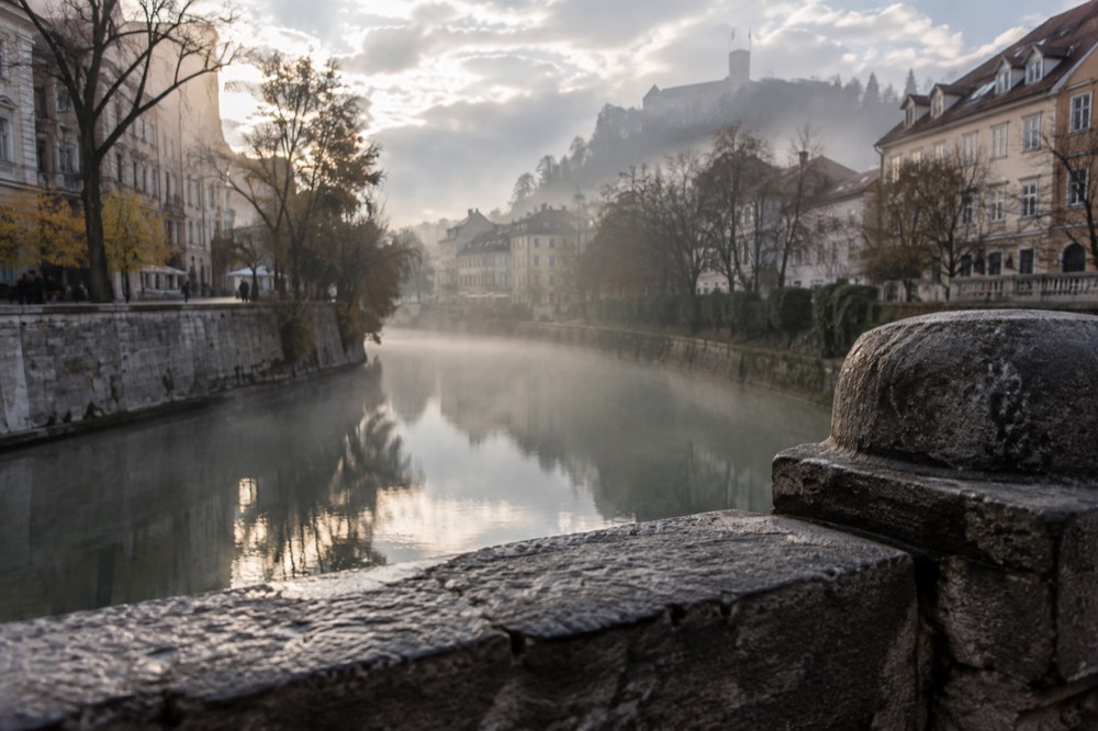 Morning mist over the Ljubljanica river and the Ljubljana skyline