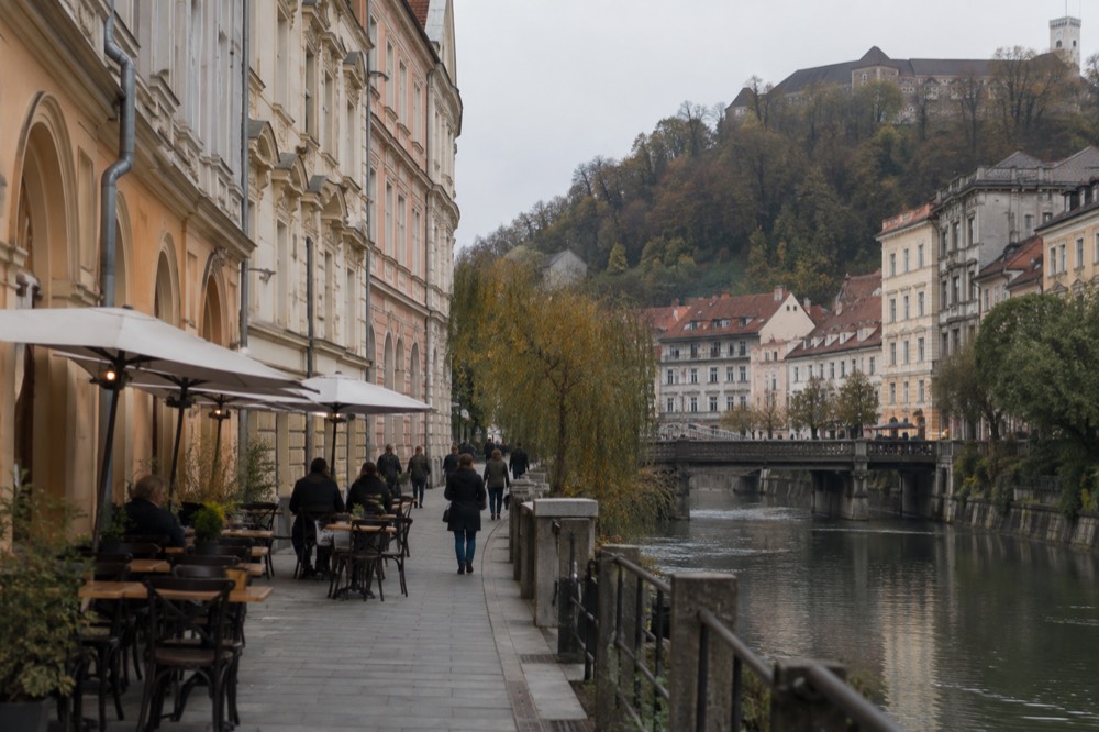 Pastel buildings and riverside tables along the pedestrianised centre of Ljubljana