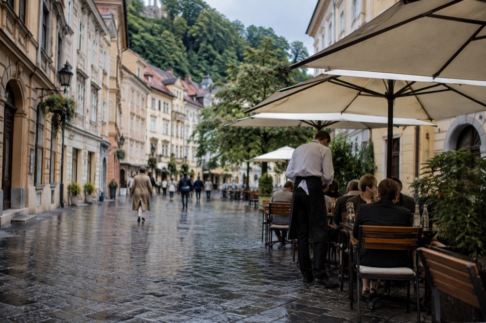 A waiter taking an order at an outdoor table on a Ljubljana square