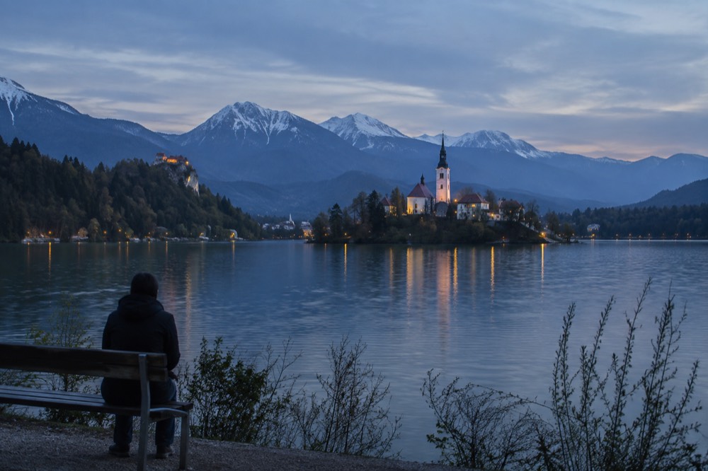 The island church on Lake Bled seen across the water from a shoreline path