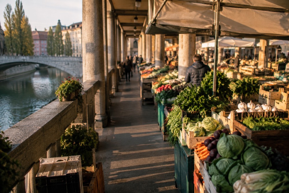 Fresh produce stalls under the covered colonnade of Ljubljana Central Market
