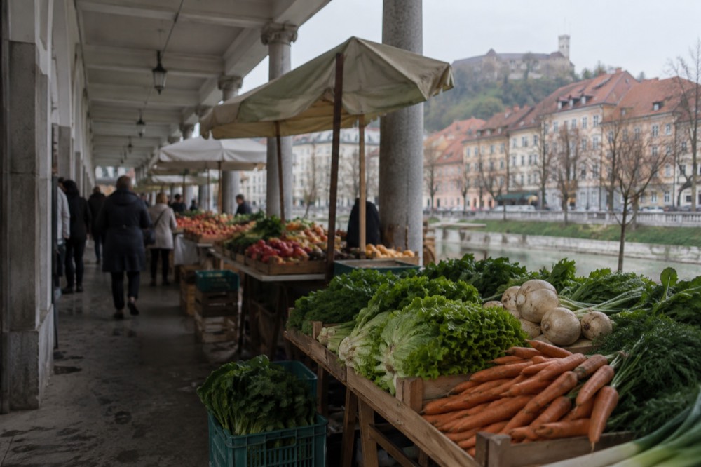 Outdoor market stalls under the colonnade of the Plečnik Central Market in Ljubljana