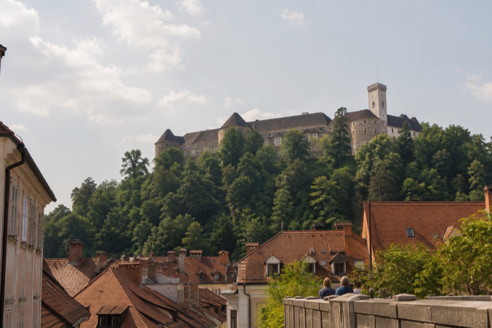 Ljubljana castle walls and tower above the red rooftops of the old town