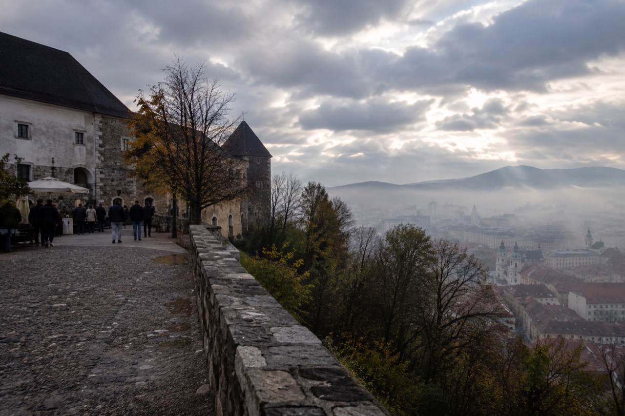 Fog resting over the Ljubljana old town rooftops and the castle hill above the city