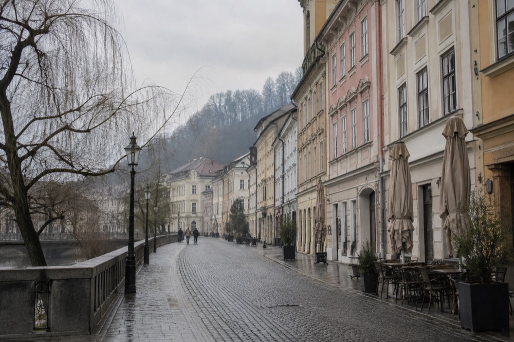 Cobbled street in Ljubljana old town on an overcast morning with café awnings closed
