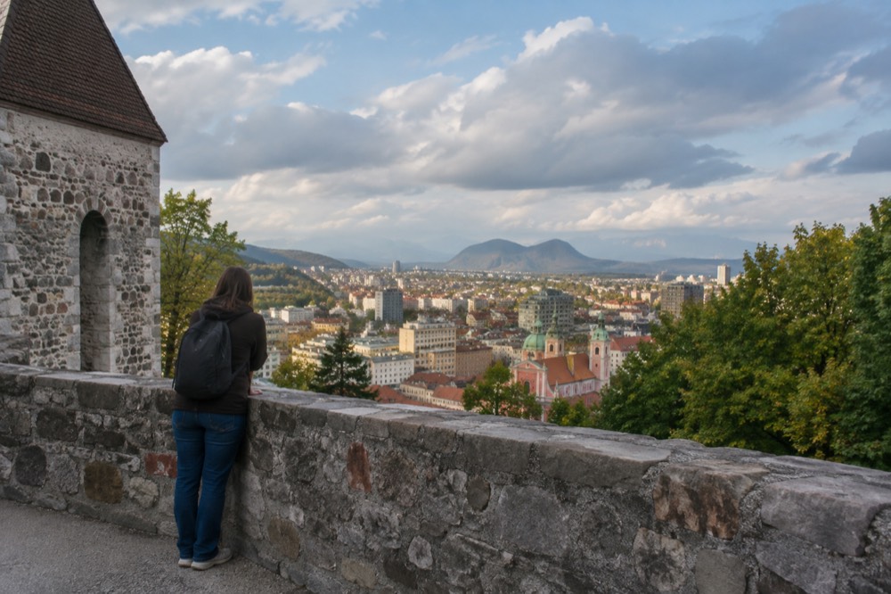 A visitor looking over the rooftops of Ljubljana old town from the castle hill
