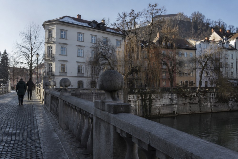 Stone bridge crossing the Ljubljanica with riverside facades behind it