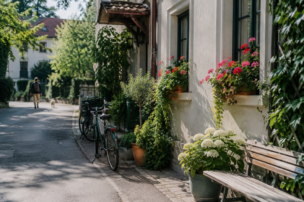 Guesthouse with flower boxes on a quiet green street with bicycles leaning against a wall