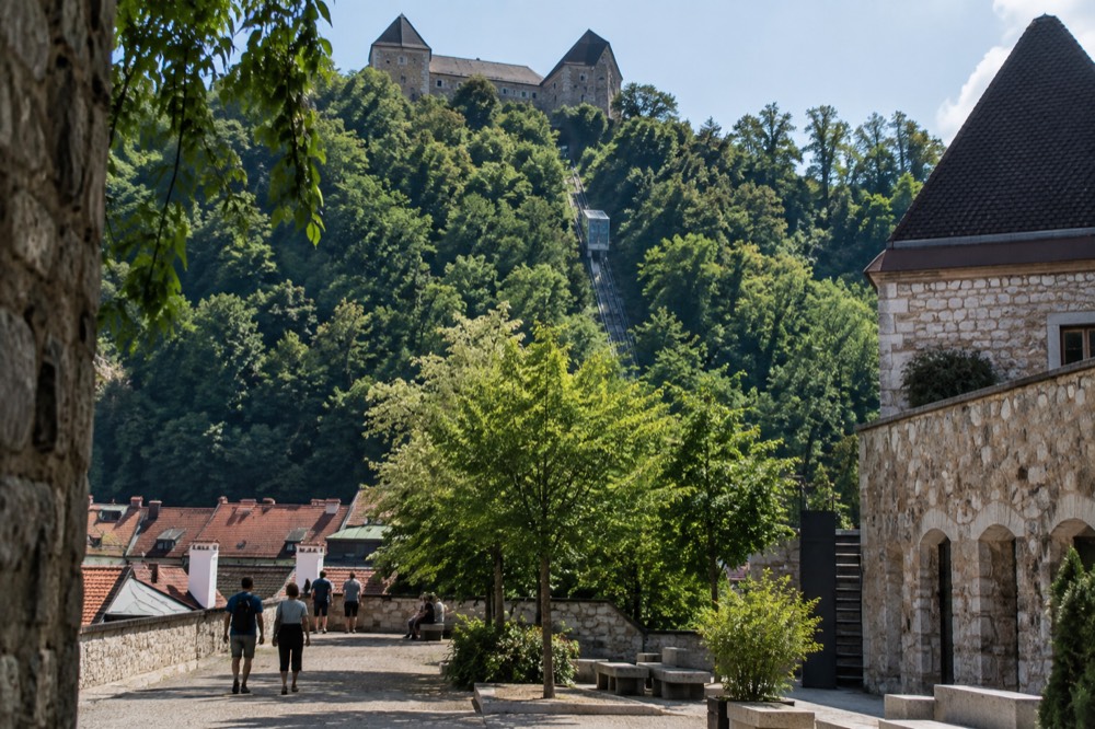 The Ljubljana Castle funicular cabin climbing the wooded hillside above the red rooftops of the old city centre