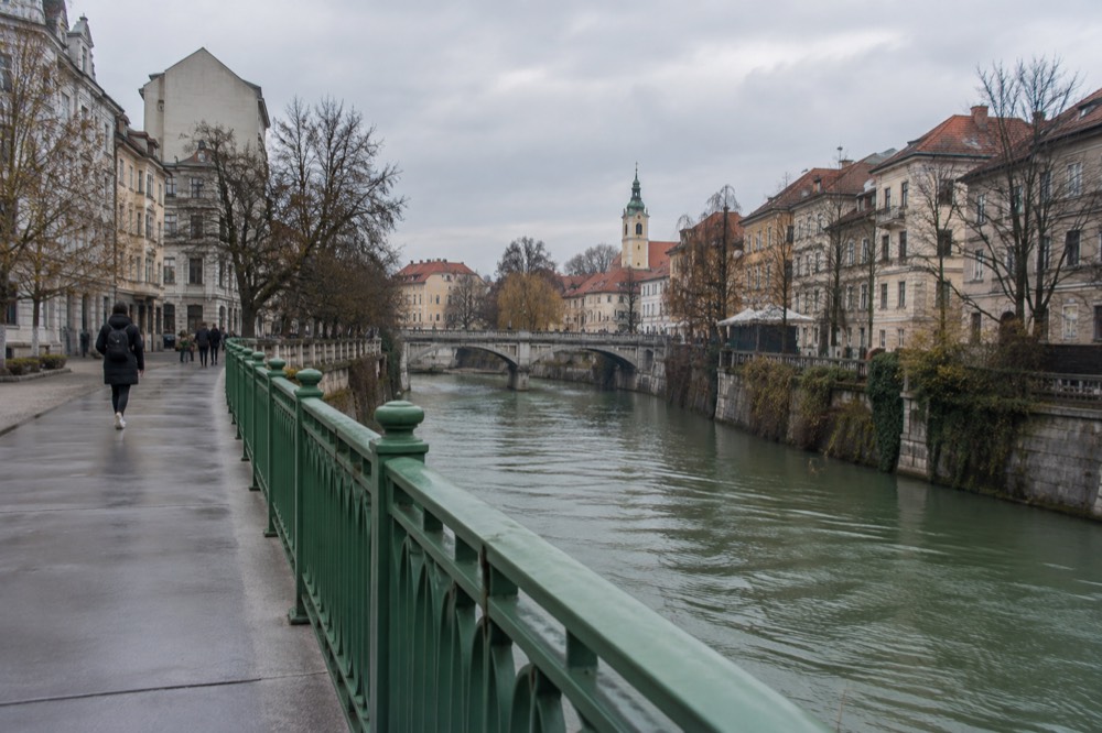 River view from a bridge looking toward another bridge and a church tower in morning light