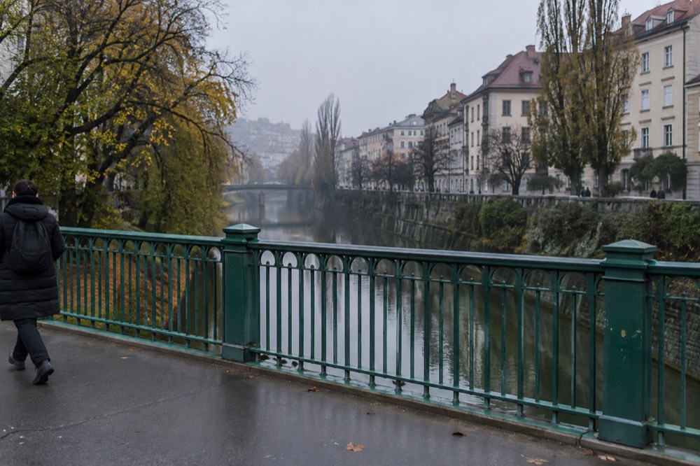 Bridge with dragon statues in soft morning fog above a calm river