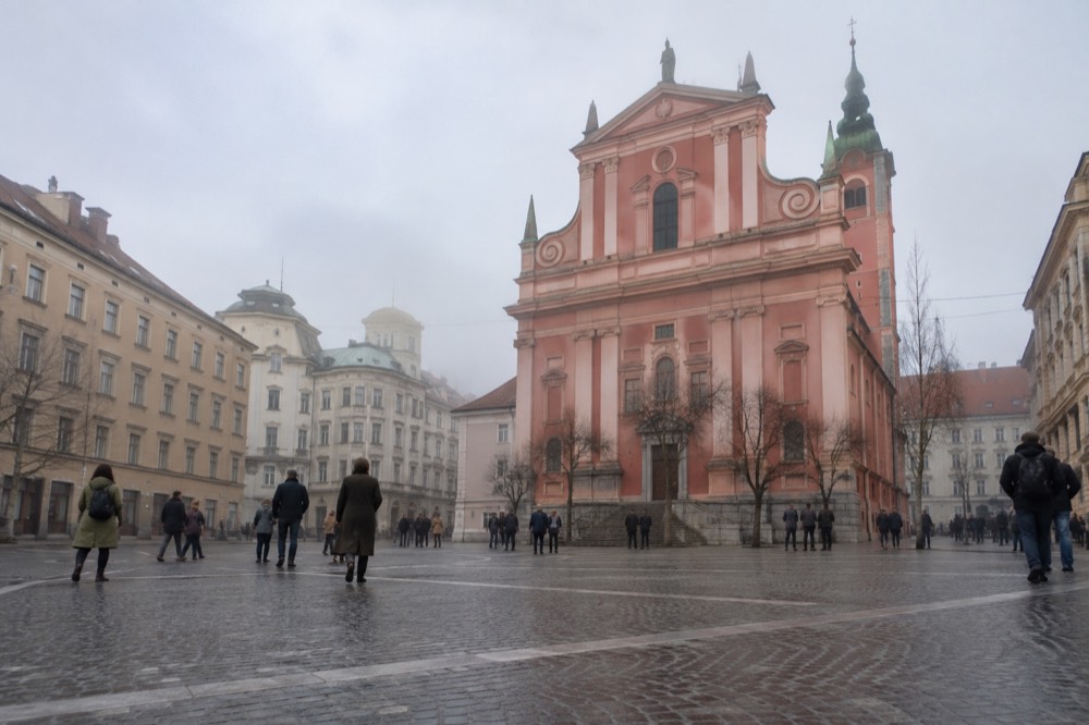 The pink facade of the Franciscan Church of the Annunciation standing above Prešeren Square in Ljubljana