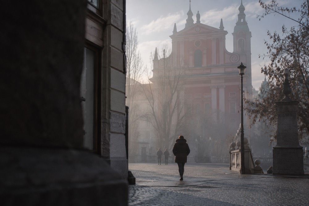 The Franciscan Church facade half hidden by morning fog over the square