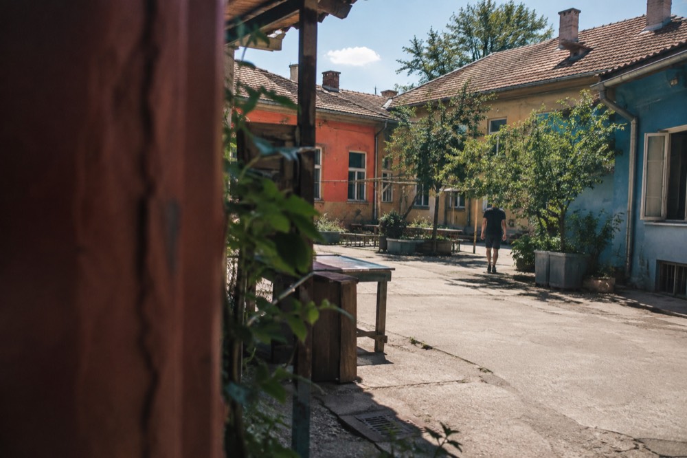 A quiet courtyard between painted barracks buildings in daylight