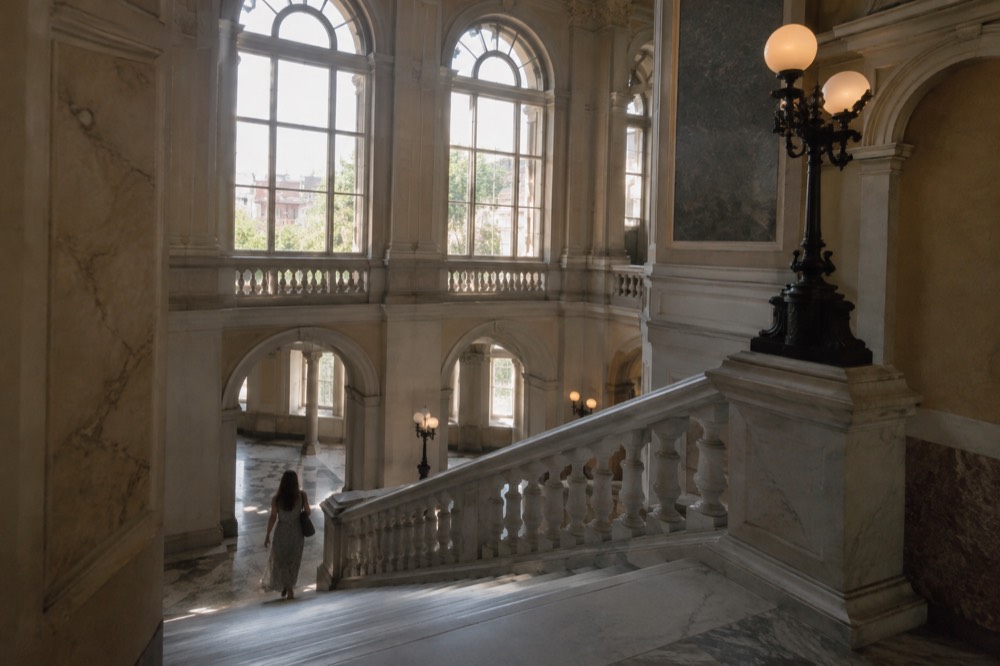 Grand staircase inside an art museum with marble floors and tall windows