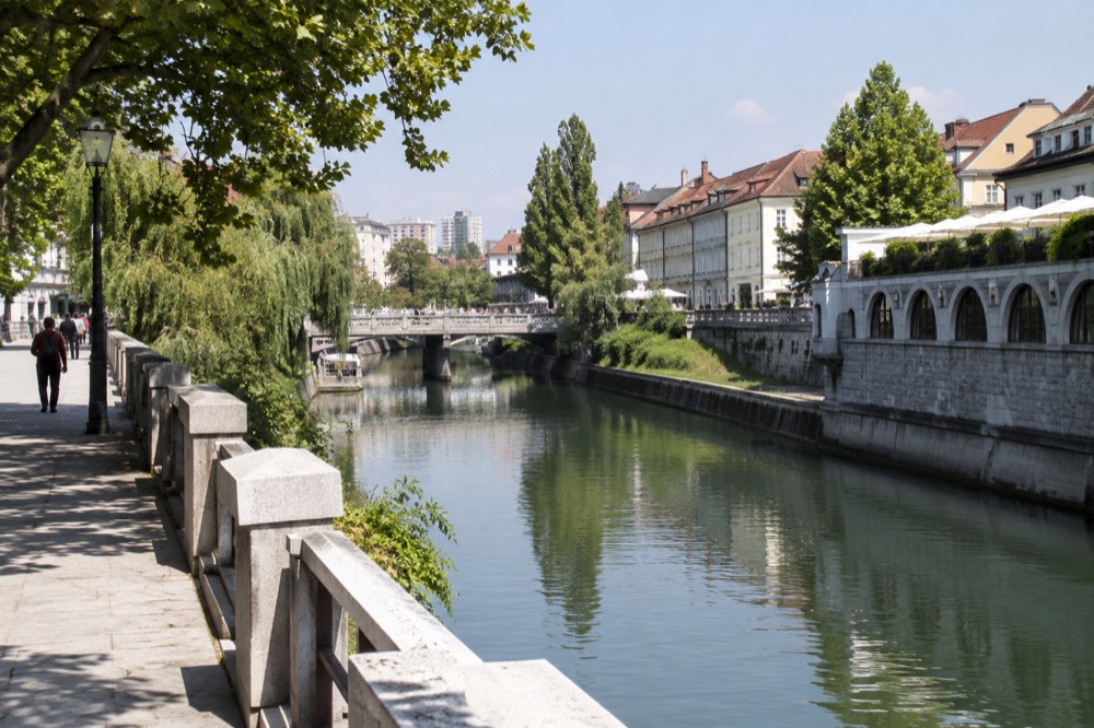 River embankment in a city centre with bridges and market buildings along the water