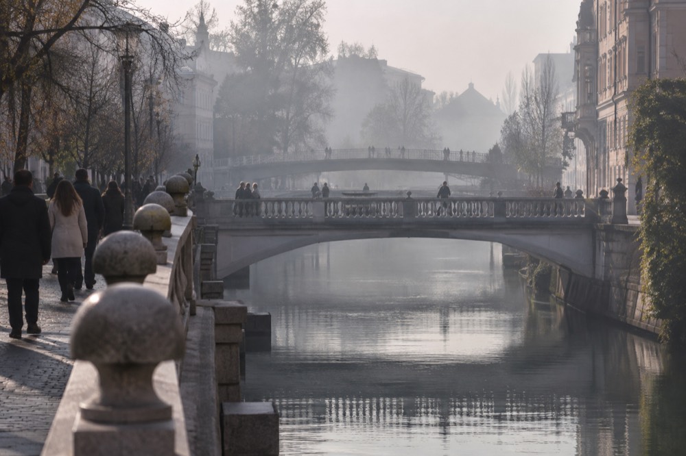 Morning fog over the river with the outlines of three bridges crossing it