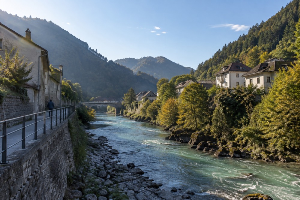a turquoise river running between steep forested slopes in the Slovenian mountains