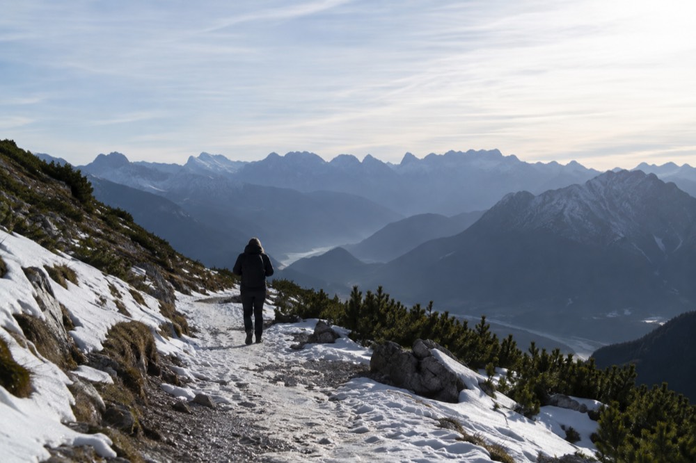 View from a high mountain pass over layered blue ridges fading into the distance