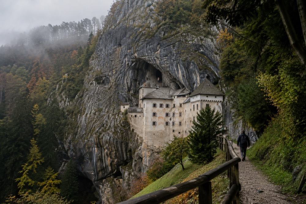 A castle cliff in morning mist with the valley floor hidden below
