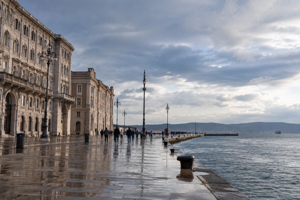 Large seafront square in Trieste with ornate buildings facing the open water