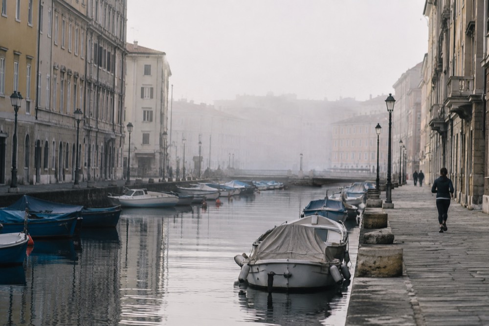 Narrow canal in Trieste lined with old buildings and moored boats