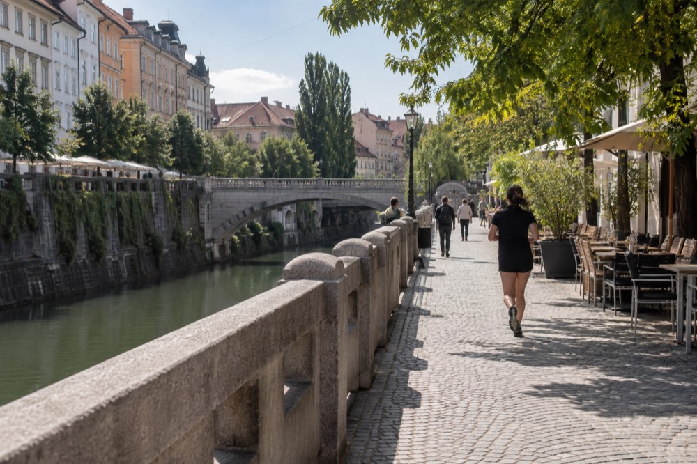 The stone embankment of the Ljubljanica river with the Triple Bridge in the background