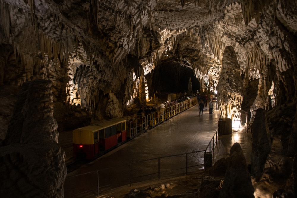 The underground railway platform inside Postojna Cave lit for visitors