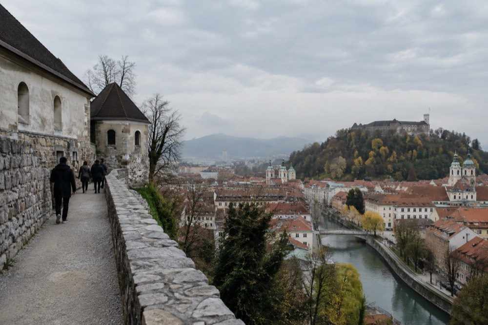 The Ljubljanica river and the old city centre under morning light, with Ljubljana Castle on the hill above