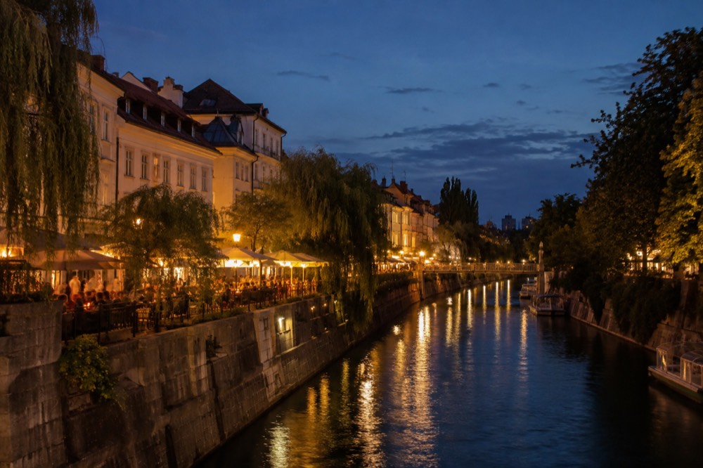 Ljubljana riverside bars lit up at night along the Ljubljanica