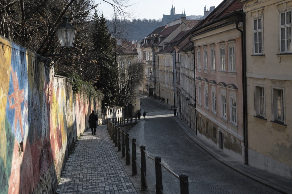 Colourful paint-covered walls on a wall beside a quiet city street