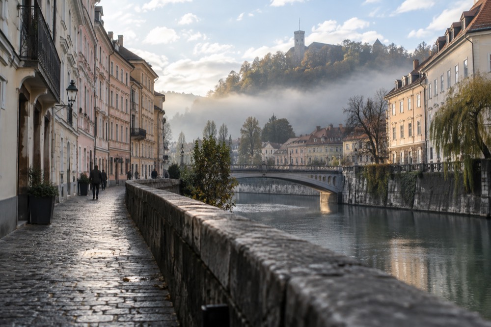 Morning mist sitting over a flat city basin with sunlit hills above the fog line