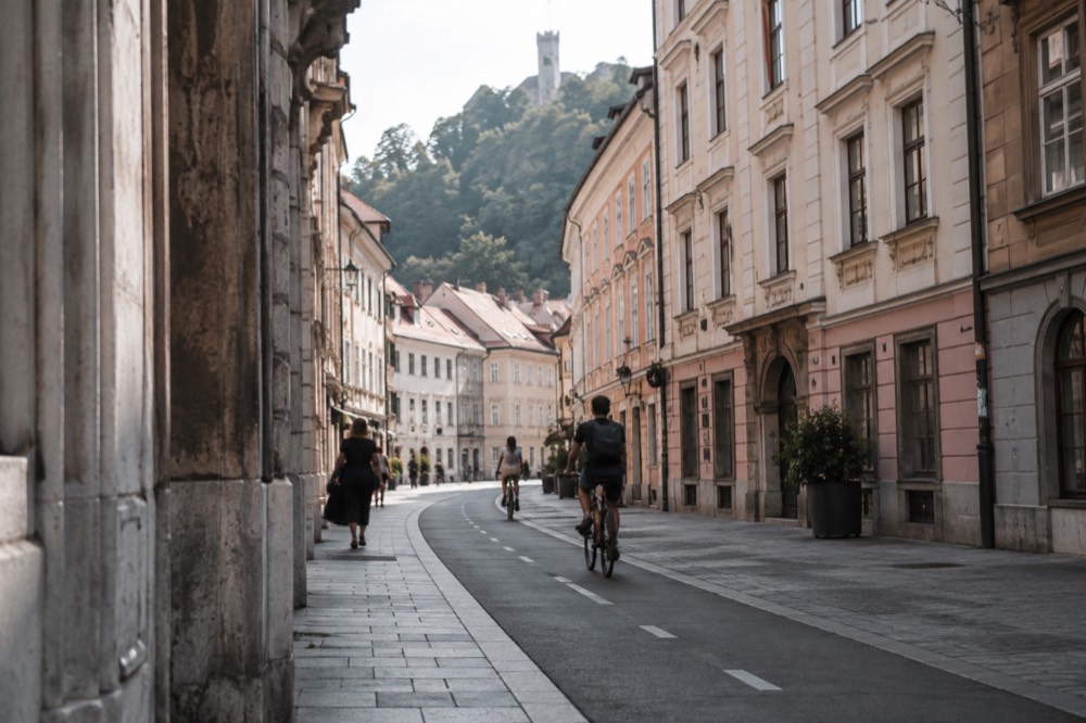 A bicycle lane marked along a city street with old buildings on both sides
