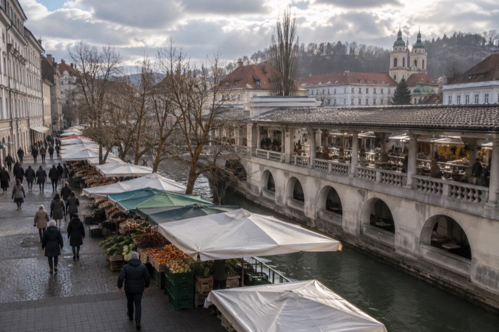 A pedestrianised city street in winter with people walking between lit buildings and no cars