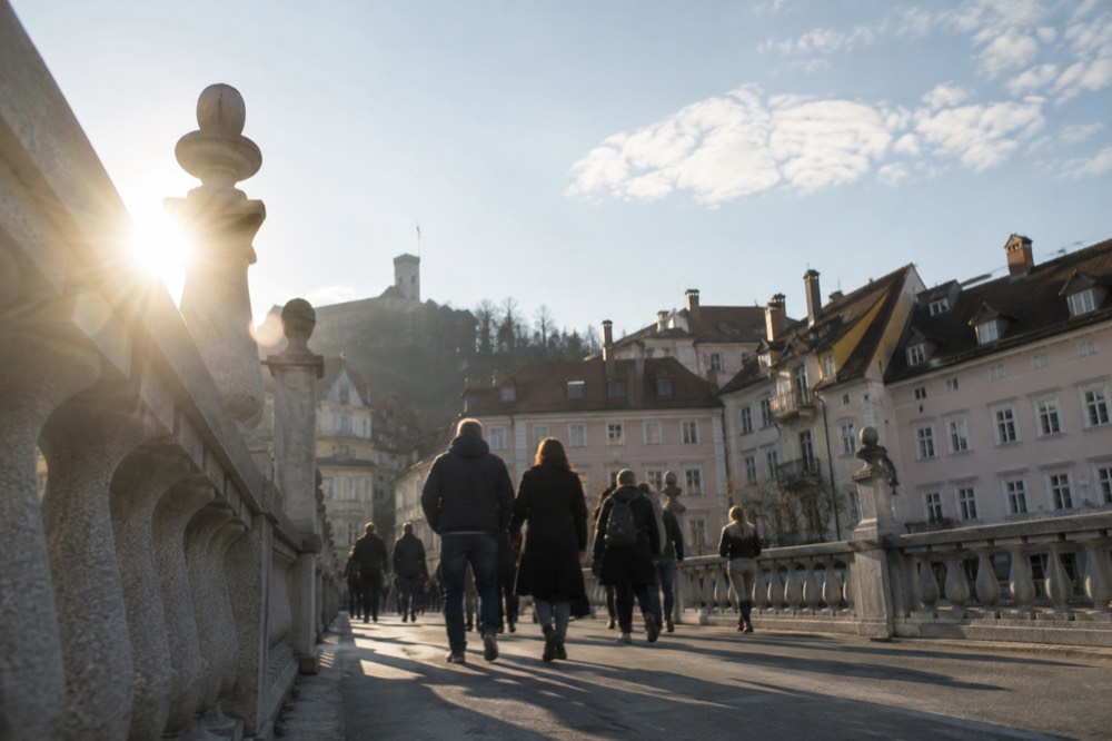 The Triple Bridge and riverside buildings of Ljubljana Old Town seen from a quiet morning crossing