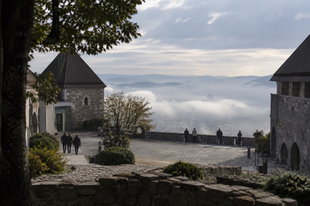 Morning fog sitting over the Ljubljana basin with the castle hill rising above the low cloud