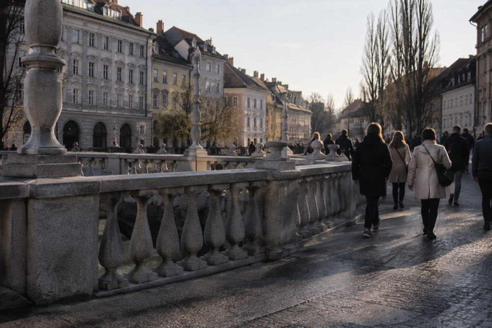 The Triple Bridge and riverside buildings of Ljubljana seen from a quiet morning street