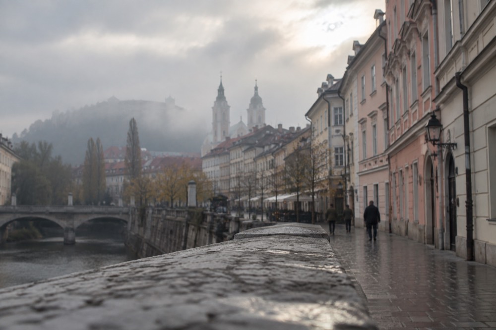 Morning fog resting over the rooftops and church spires of central Ljubljana