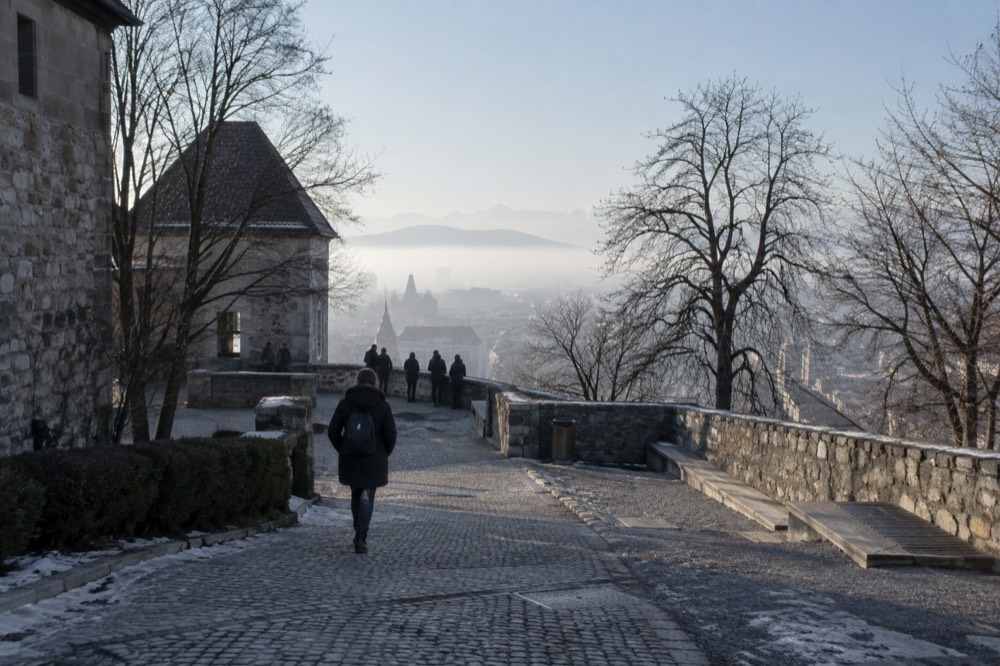 Fog resting over the Ljubljana skyline with the castle hill faintly visible above the mist
