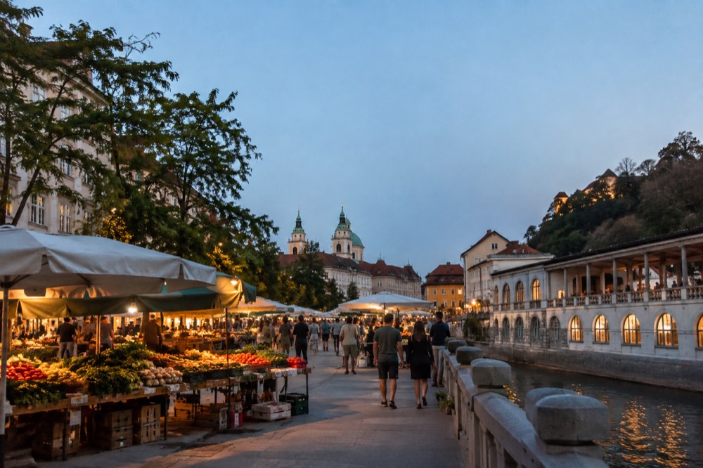 Food stands and crowds filling a city square on a warm Friday evening