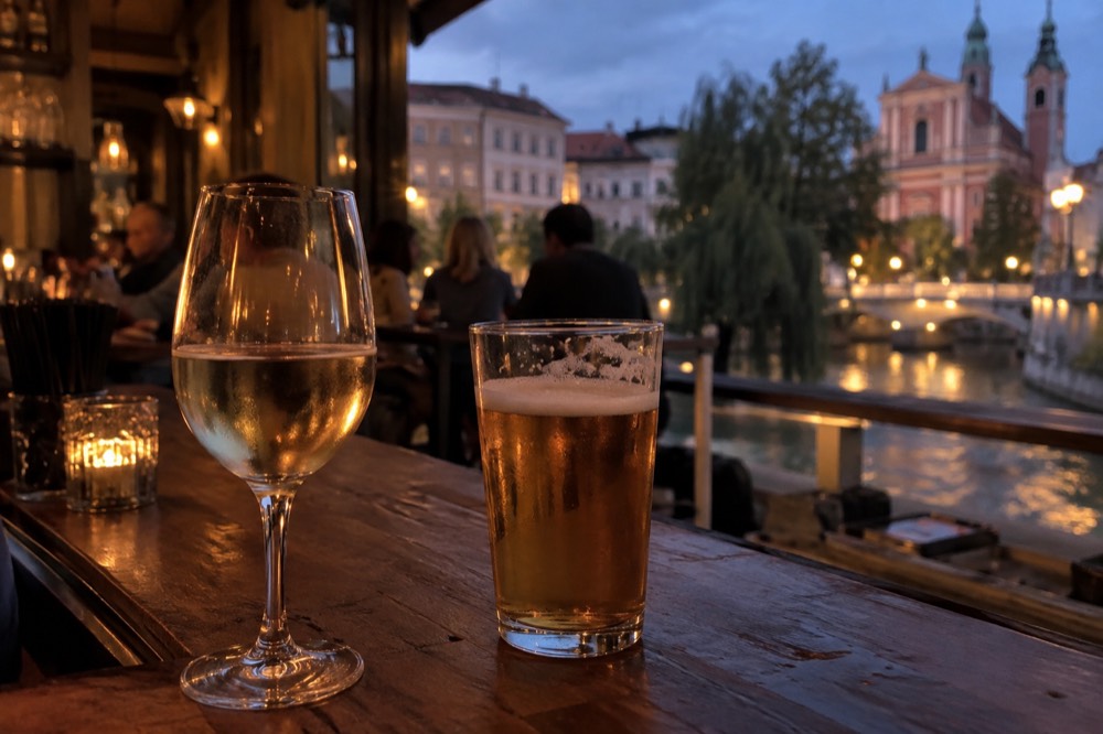 Glasses of local wine and beer on a wooden bar counter in a small Ljubljana bar